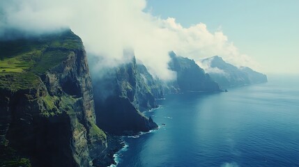 Breathtaking coastal cliffs adorned with mist along a tranquil blue ocean.