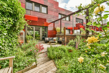 Modern home with lush garden and red facade