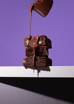 Stacked chocolate brownies with flowing chocolate sauce