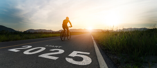 New year 2025 or start straight and beginning concept.Blurry Man ride on bike and word 2025 start written on the road at sunset add lens flare.Concept of challenge or career path,business strategy.