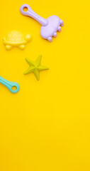 Plastic beach toy pastel color on yellow background. The development of fine motor concept. Creativity Game and summer concept.