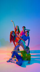 Group portrait of young, teenage girls posing, each showing her individuality in neon light against gradient studio background. Concept of sport and hobby, childhood, friendship, motion. Dance lessons