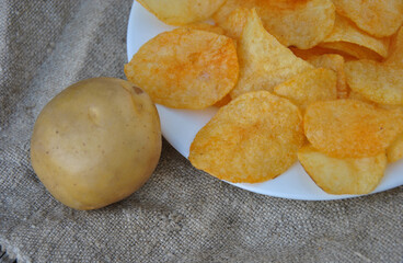potato chips on a plate and potatoes close-up. selective focus