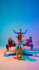 Dancers create powerful and dynamic visual experience in neon light against gradient studio background. Concept of sport and hobby, childhood, friendship, motion. Dance lessons.