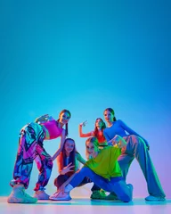 Dancers posing, their energy and confidence radiating as they prepare to bring their choreography to life in neon light against gradient background. Concept of childhood, friendship, motion