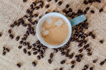 A cup of coffee with coffee beans