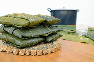 Hallacas, pasteles o paime con olla tiznada al fondo. Gastronomía típica del Caribe para la cena navideña.