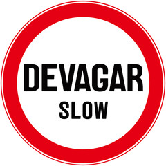 A circular sign that says in English and Portuguese language: slow