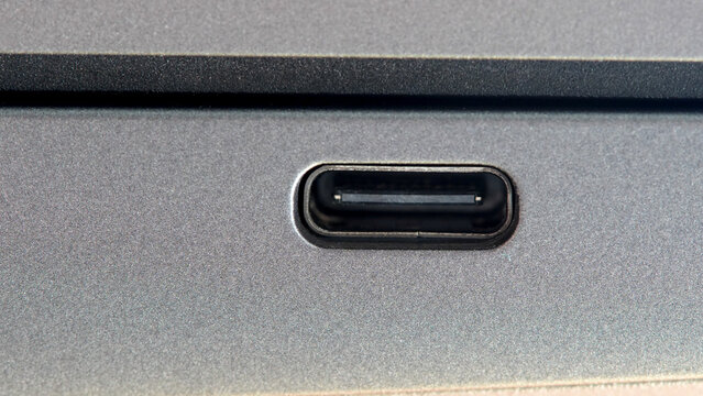 USB-C data charging monitor output port input on the side of a modern laptop computer, macro shot, extreme closeup detail, nobody, front view. USB C connection standard simple concept, no people