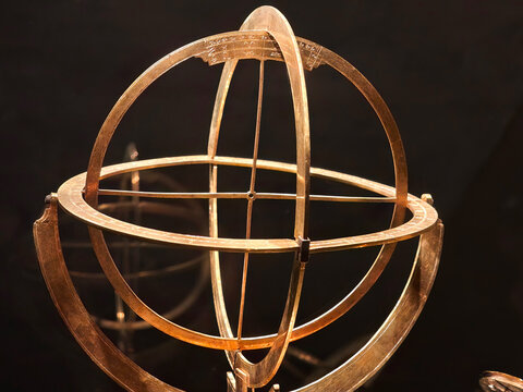Old golden Armillary sphere on dark background, spherical astrolabe, armilla armil celestial spheres sky objects model rings closeup detail nobody Medieval astronomy astrology abstract concept, symbol