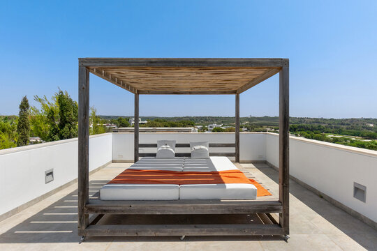 Luxury outdoor bed on modern rooftop terrace