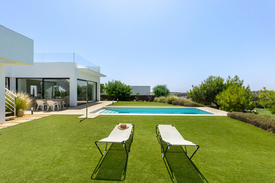 Modern home with pool and lush garden on a sunny day
