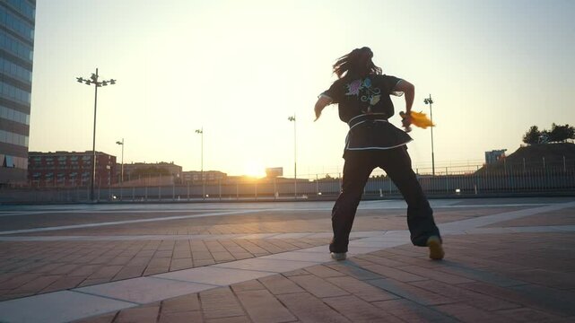 Young woman training in kung fu wushu martial arts outdoor with weapons and swords.