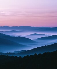 Obraz premium Dawn breaks over misty blue mountains in serene early morning light
