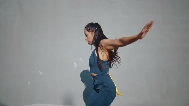 Young woman training in kung fu wushu martial arts outdoor with weapons and swords.
