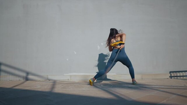 Young woman training in kung fu wushu martial arts outdoor with weapons and swords.