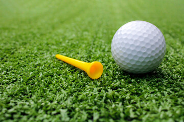 Picture of a golf ball and yellow golf tee.