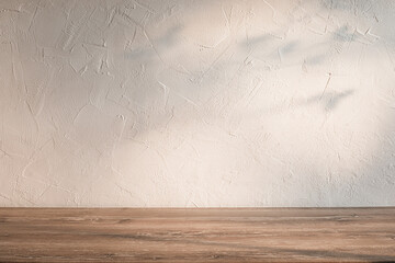 Natural light and shadows on textured wall and wooden tabletop. Kitchen background.