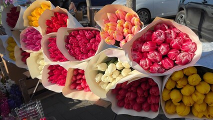 Selling bouquets of tulips on the city street.
