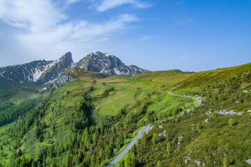 Snake Road in the Dolomites. Sunrise aerial forest. Pathway from Snake Road to high mountain range in Giau Pass