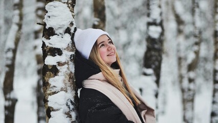 Portrait of a girl in winter in a birch forest.