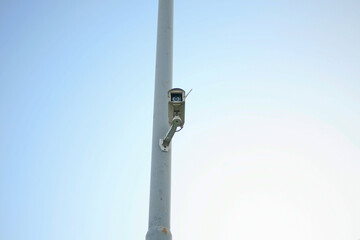 security camera hanging on power pole isolated on blue background