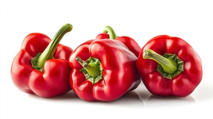 Four red bell peppers arranged on a white background, showcasing their vibrant color and shape.