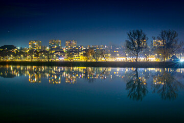 Nocna panorama miasta odbijającego się w spokojnej tafli wody © Krzysztof Rostkowski