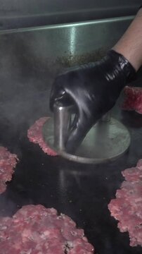 close up of a cheff smashing hamburgers