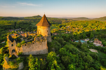 Naklejka premium Ruins of a medieval castle Somoska or Somoskoi var on borders of southern Slovakia and Hungary at sunrise time. .Salgo Castle or Salgo vara in background
