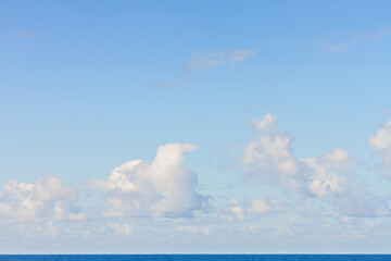 Blue sky background with puffy white clouds