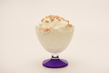 Ice cream in a glass ice cream maker with pine nuts. Ice cream with nuts.