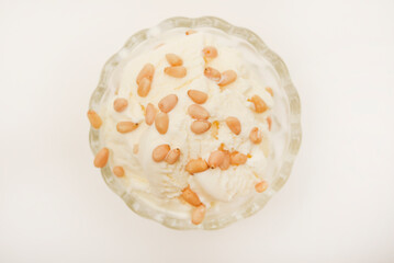 Ice cream in a glass ice cream maker with pine nuts. Ice cream with nuts.