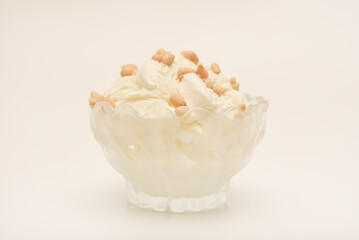 Ice cream in a glass ice cream maker with pine nuts. Ice cream with nuts.