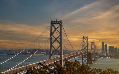 Sunset time view of Oakland Bay Bridge in San Francisco with golden clouds