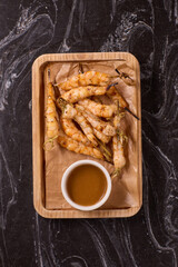 Delicious Grilled Shrimp Accompanied by a Sauce on a Rustic Wooden Platter for Serving