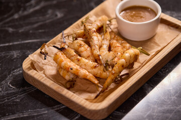 Delicious Grilled Shrimp Accompanied by a Sauce on a Rustic Wooden Platter for Serving