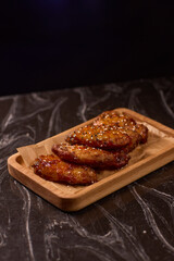 Succulent and Deliciously Glazed Asian Style Chicken Wings Served on a Wooden Platter