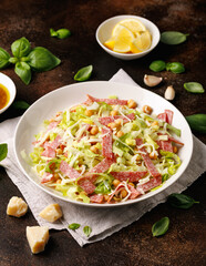La Scala Salad with romaine lettuce, salami, mozzarella cheese and chickpeas in white plate.