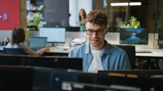 Smiling programmer typing keyboard working computer at office workplace closeup