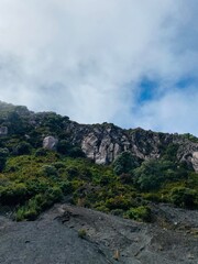 photo of the summit of volcano irazu, Costa Rica, early in the morning, mist is visible. The rocks are covered with small plants