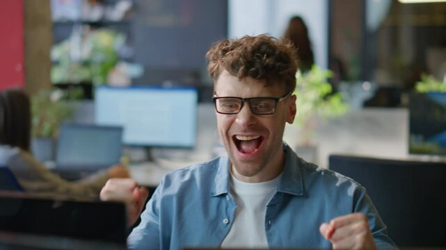 Joyful employee celebrating promotion email in office closeup. Happy man winner