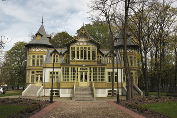 Charming Yellow Half-Timbered Mansion with Ornate Windows and Steep Gables