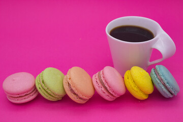 Colorful Macarons and Coffee on Pink Background