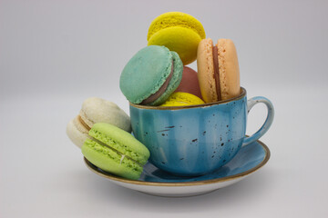 Vibrant Macarons in a Rustic Blue Cup on White Background