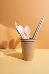 Kraft paper tableware: cups, food boxes, isolated on a light background. A set of various disposable tableware. Recycling and zero waste concept. Mock up