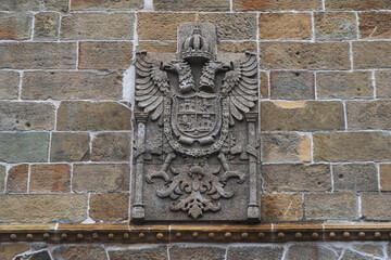 Ancient coat of arms carved in dark grey rock
