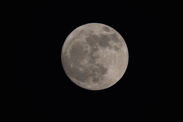 photograph of the full moon partially covered with clouds