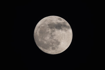 photograph of the full moon partially covered with clouds