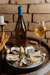 Fresh oysters on ice with lemon wedges and wine, ideal for gourmet dining and celebrations